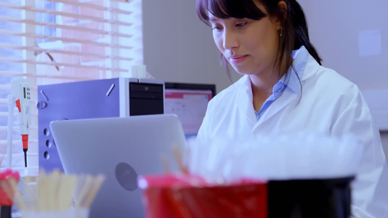 técnico de laboratorio usando una computadora portátil en un banco de sangre 4k