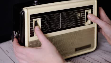 un dedo femenino sintonizando la frecuencia en un viejo receptor analógico vintage. 4k