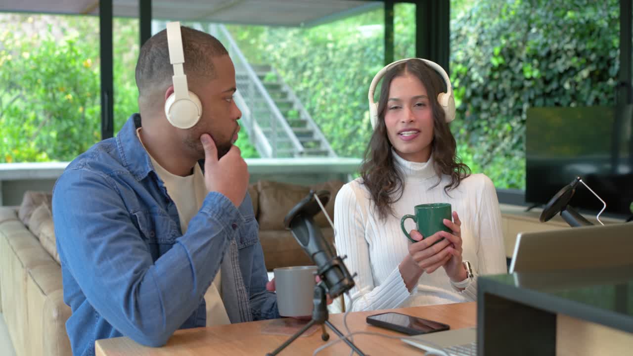 Diverse medverter gjør opptak mens mann justerer mikrofon, scroller på telefonen, kvinne som drikker kaffe ved disken