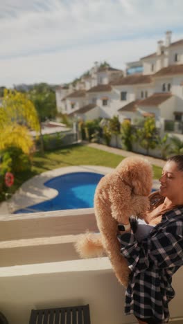 woman enjoying a sunny day with her poodle on a patio