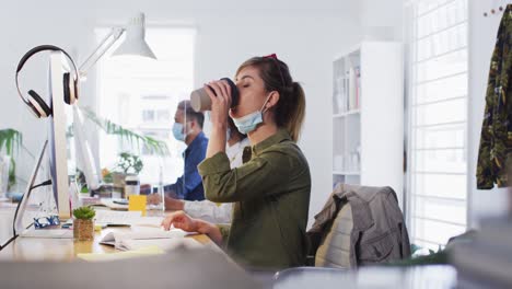 Frau-Trinkt-Kaffee,-Während-Sie-An-Ihrem-Schreibtisch-Im-Büro-Sitzt