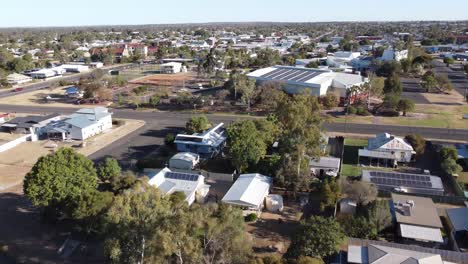 drone approaching a large shed with solar panels on top in a regional town in australia