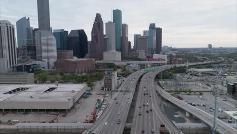 aerial view of traffic on freeway near downtown houston on a cloudy day during sunset