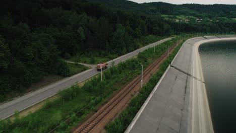 aerial of construction truck driving with building materials along the railway