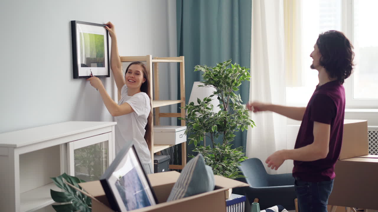 Couple Moving In and Hanging a Picture