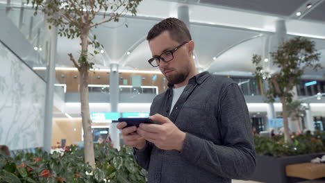 hombre usando un teléfono inteligente en una terminal del aeropuerto