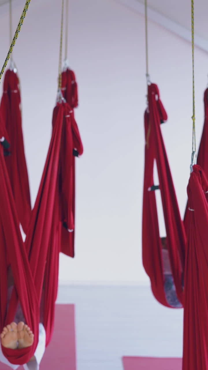 hanging anti-gravity yoga hammocks with sleeping tired women with bare feet relaxing after hard workout