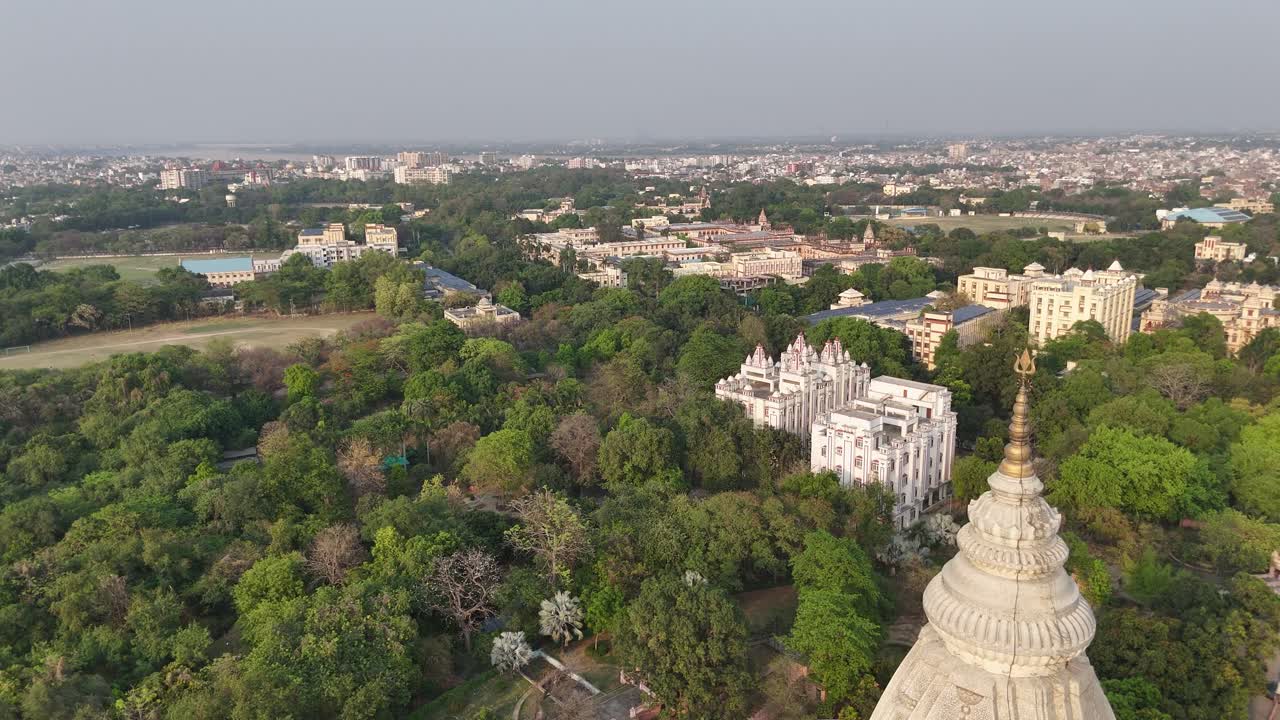 Aerial perspective of Varanasi's dense urban sprawl, with temples reflecting the timeless connection