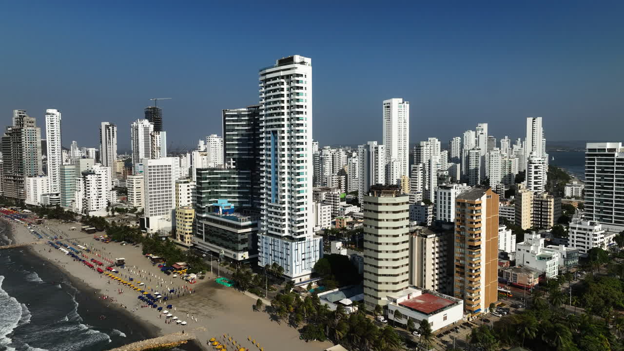 vista aérea lejos de la playa y hoteles en la soleada bocagrande, cartagena, colombia - retroceso, disparo de drones