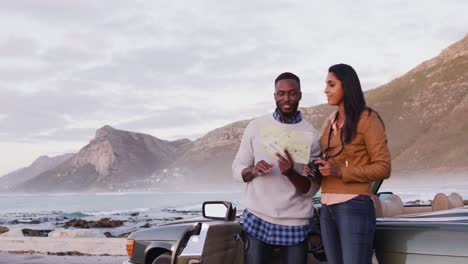 Pareja-Afroamericana-Usando-El-Mapa-Para-Obtener-Direcciones-Mientras-Está-De-Pie-Cerca-Del-Auto-Convertible-En-La-Carretera