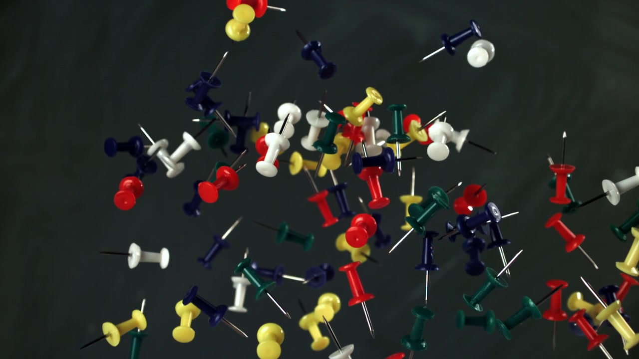 Colorful Pushpins Falling and Floating in Slow Motion