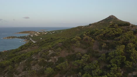 Drone-aerial-view-of-a-mountain-landscape-surrounded-by-sea