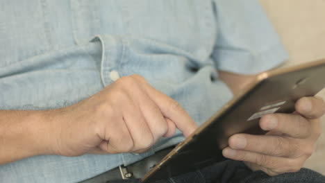 Close-Up-Of-A-Man-Navigating-On-His-Tablet