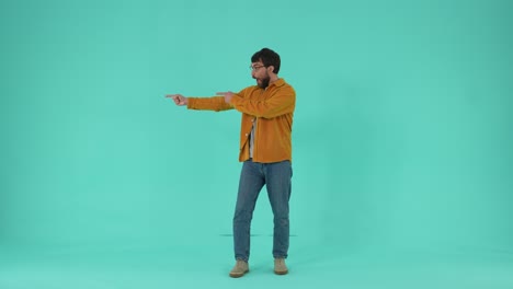 un hombre alegre señalando con los dedos aislado en el estudio.