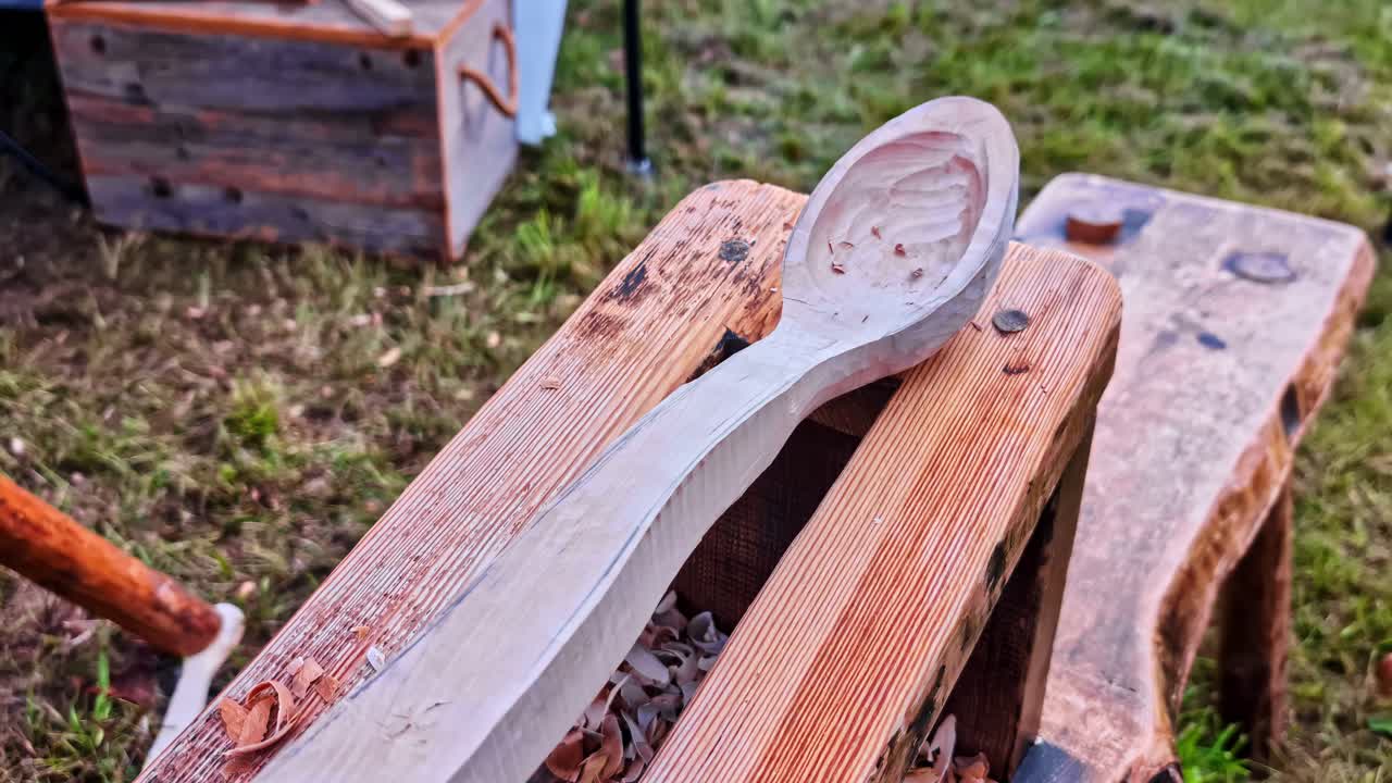 Handcrafted wooden spoon on rustic table outdoors, relaxed craft vibe