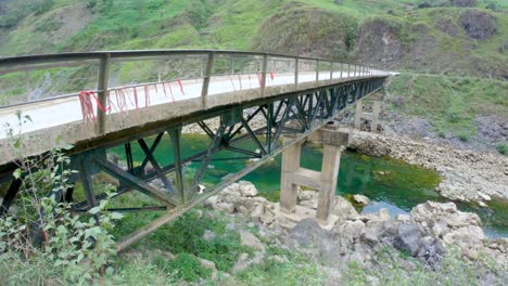 a rickety old bridge connects to mountains side communities in northern vietnam