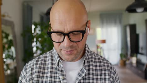 man wearing earbuds and glasses during a video call