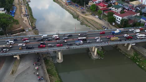 aerial overview of bustling traffic along marikina bridge and river at marikina city, luzon, philippines.