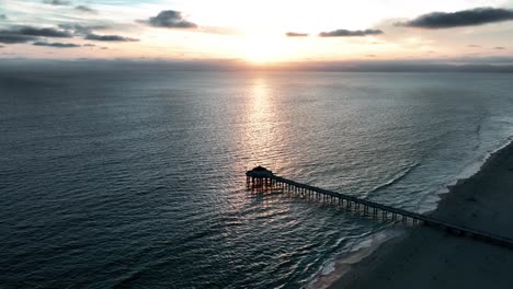 silhouettes over manhattan beach pier illuminated by golden sunlight in california, usa