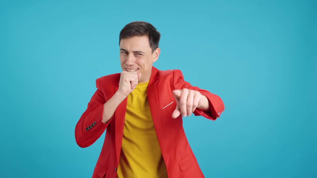 Man coughing and pointing in red jacket