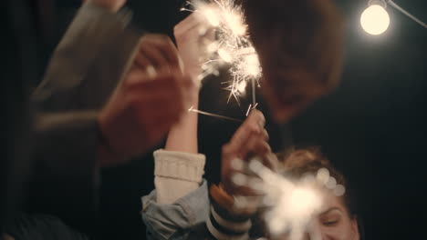 happy-friends-holding-sparklers-celebrating-new-years-eve-birthday-party-at-night-having-fun-holiday-celebration-gathering-on-rooftop