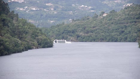 wide-view-around-a-tourist-cruise,-in-a-valley,-between-gardens-and-terraced-vineyards-on-the-Douro-river,-Portugal