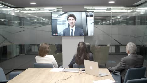 empleados escuchando al joven líder durante una videoconferencia