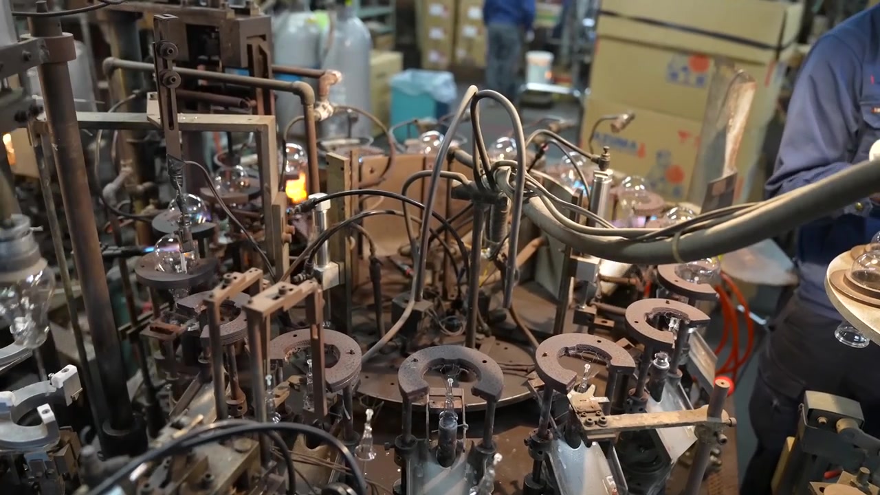 Macchina rotativa per la formatura del vetro che contiene decine di involucri di lampadine in un laboratorio