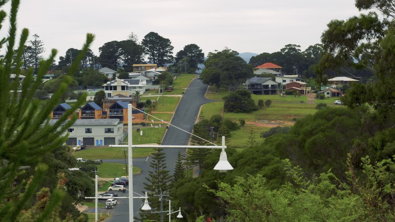 A view of a residential neighborhood with houses and a winding road on a hillside