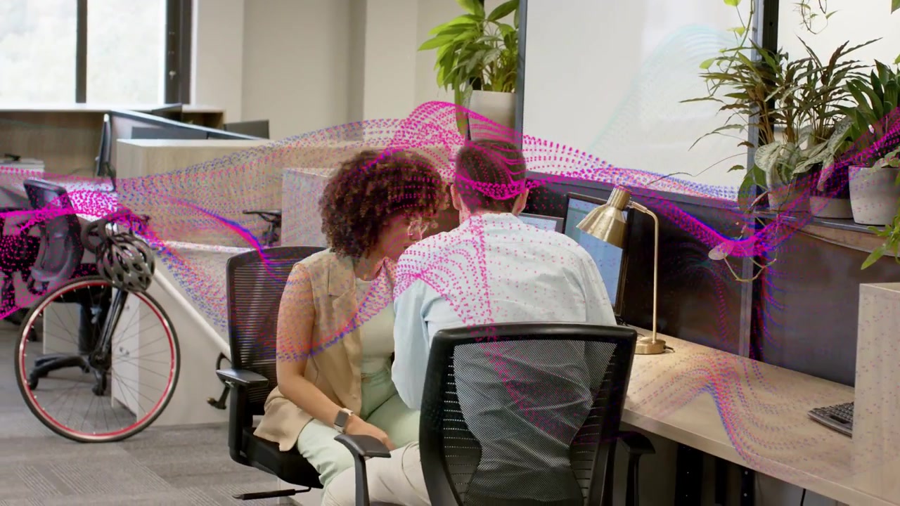 Vertikal video: Kvinde ser på et diagram på en bærbar computer, da en mand kommer ind, en magenta-pink bølge udløser arbejdschat.