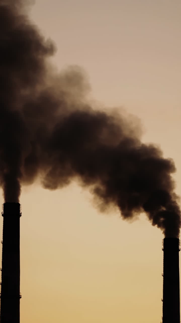 Massive air pollution. Dark dense smoke coming out from huge pipes in the evening. The death of nature and life on Earth. Vertical video