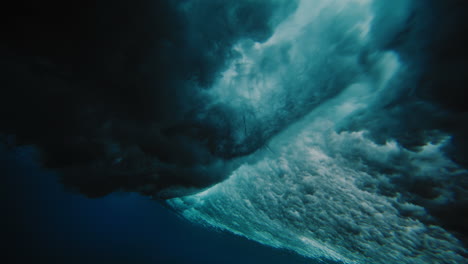 Pan-underwater-follows-surfer-riding-wave-at-Cloudbreak-Fiji-view-from-below-of-textured-water