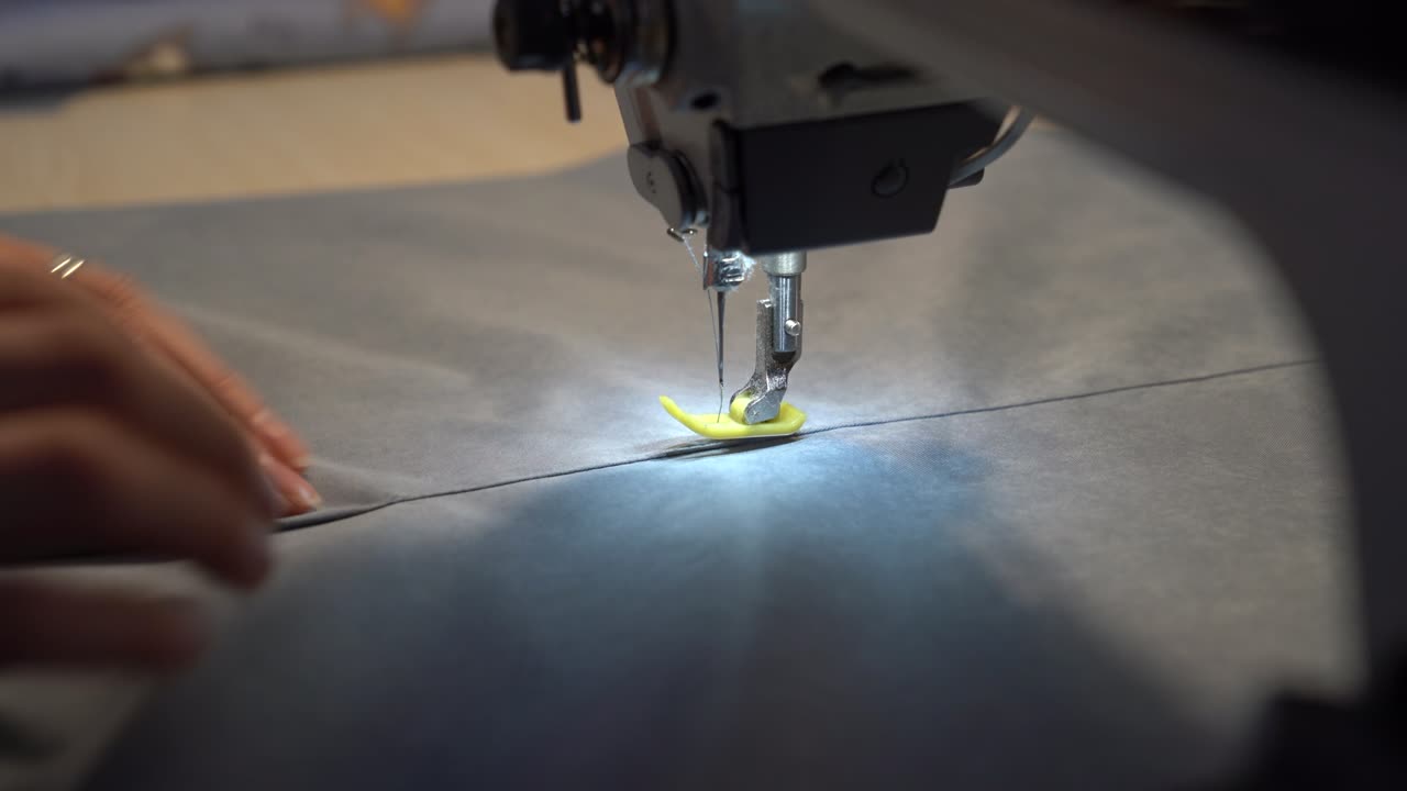 Seamstress work on sewing machine, closeup. Woman fashion designer create new clothes collection