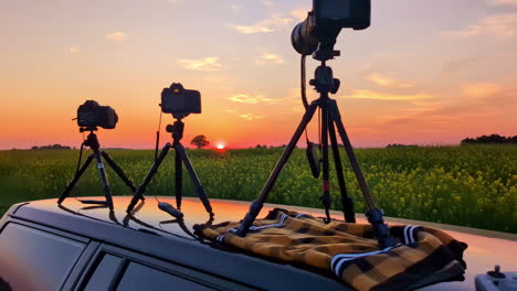 cameras on a car roof capturing a stunning sunset over a field