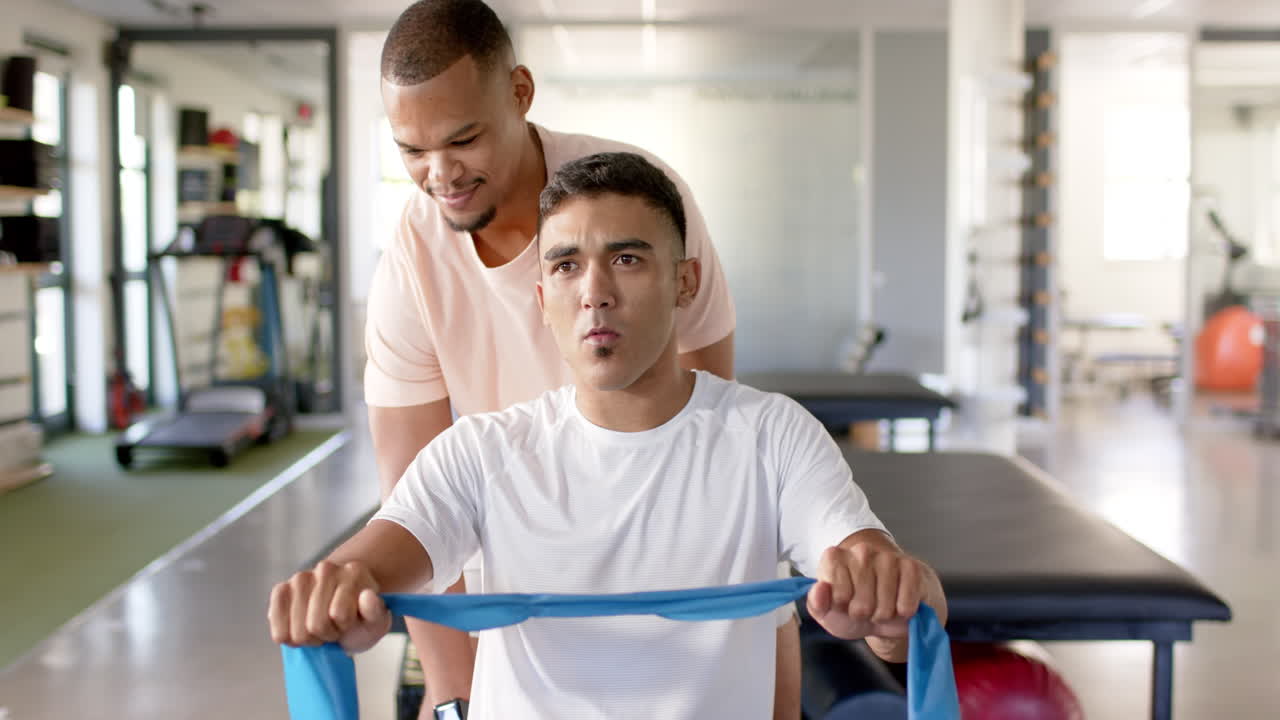Assisting in physical therapy, man with disability using resistance band
