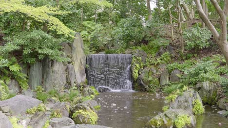 waterfall in koishikawa korakuen gardens in tokyo among greenery