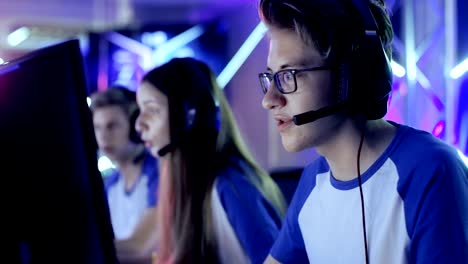 un equipo de jugadores adolescentes juega en un videojuego multijugador en un torneo de esports. el capitán da comandos al micrófono, tratando de ganar el juego estratégicamente.