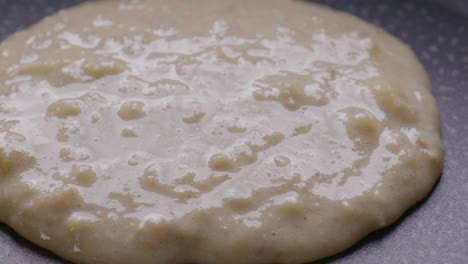 extreme close-up of pouring pancake batter on a hot pan