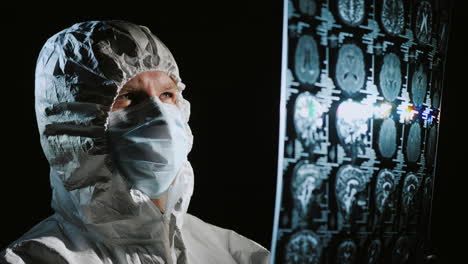 doctor in protective clothing looks at the results of the patient's examination 1