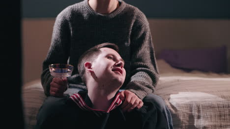 two men enjoying drinks together in a home setting