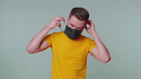 Sad-unhappy-man-putting-on-face-medical-mask-prevent-respiratory-Coronavirus-infection-flu-disease