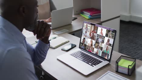hombre mayor afroamericano teniendo una videoconferencia con colegas en la computadora portátil en la oficina
