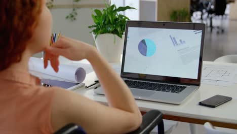 Rear-view-of-disable-young-caucasian-businesswoman-working-on-laptop-in-a-modern-office-4k