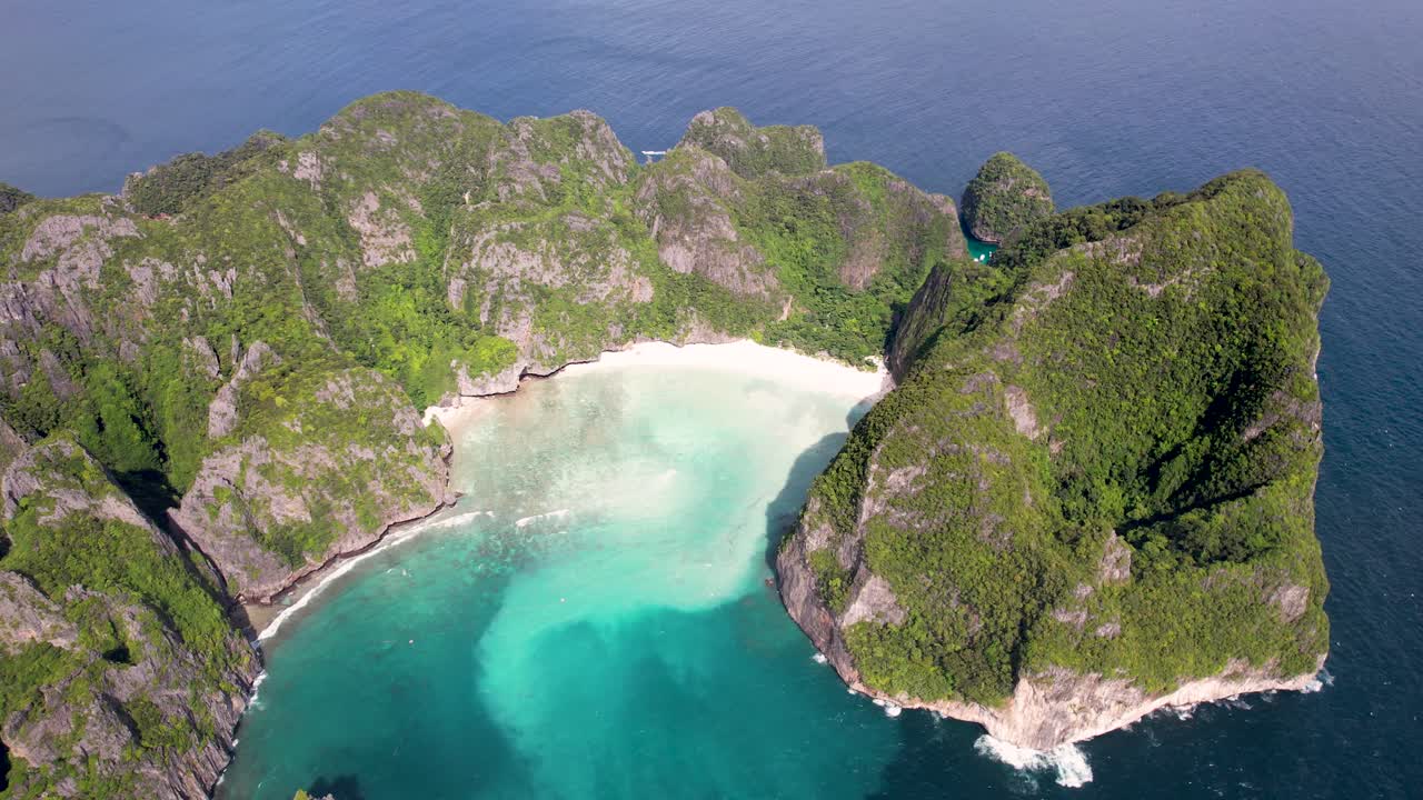 Aerial 4K drone video of Phi Phi Leh with Maya Bay and Pileh Lagoon, Krabi province, Thailand. Aerial top view of amazing tropical island with turquoise water and white beach, famous destination.
