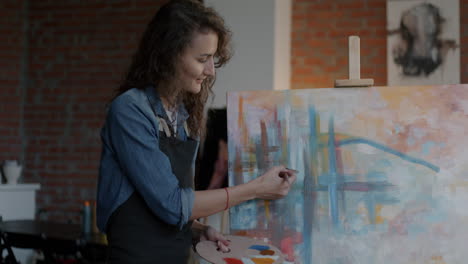 mujer pintando en un estudio de arte