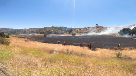 firefighters battling a wildfire in a dry landscape