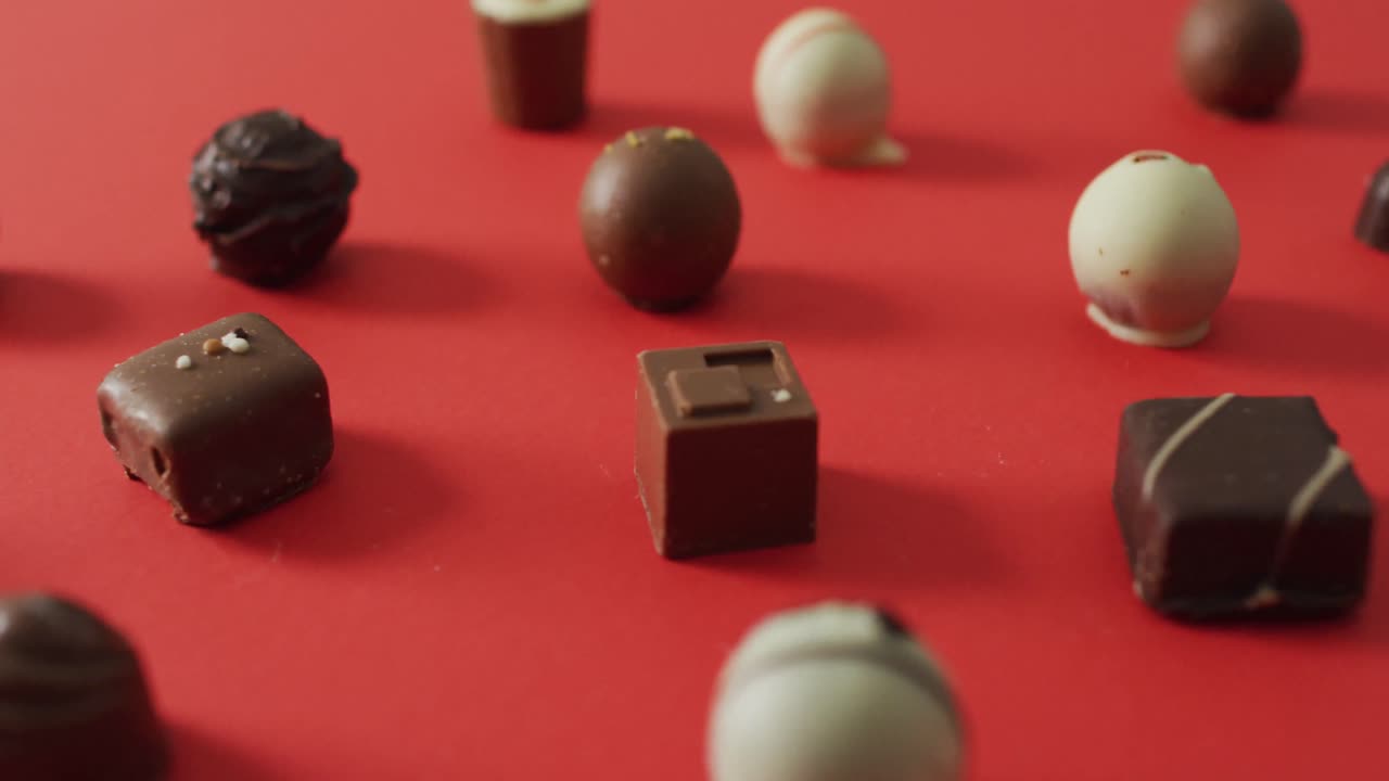 Black and white chocolates on red background at valentine's day