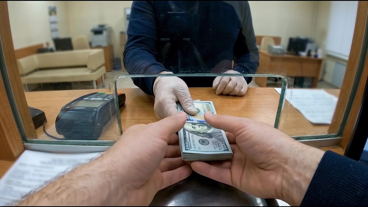 Investor holding stack of us dollar bills over the counter