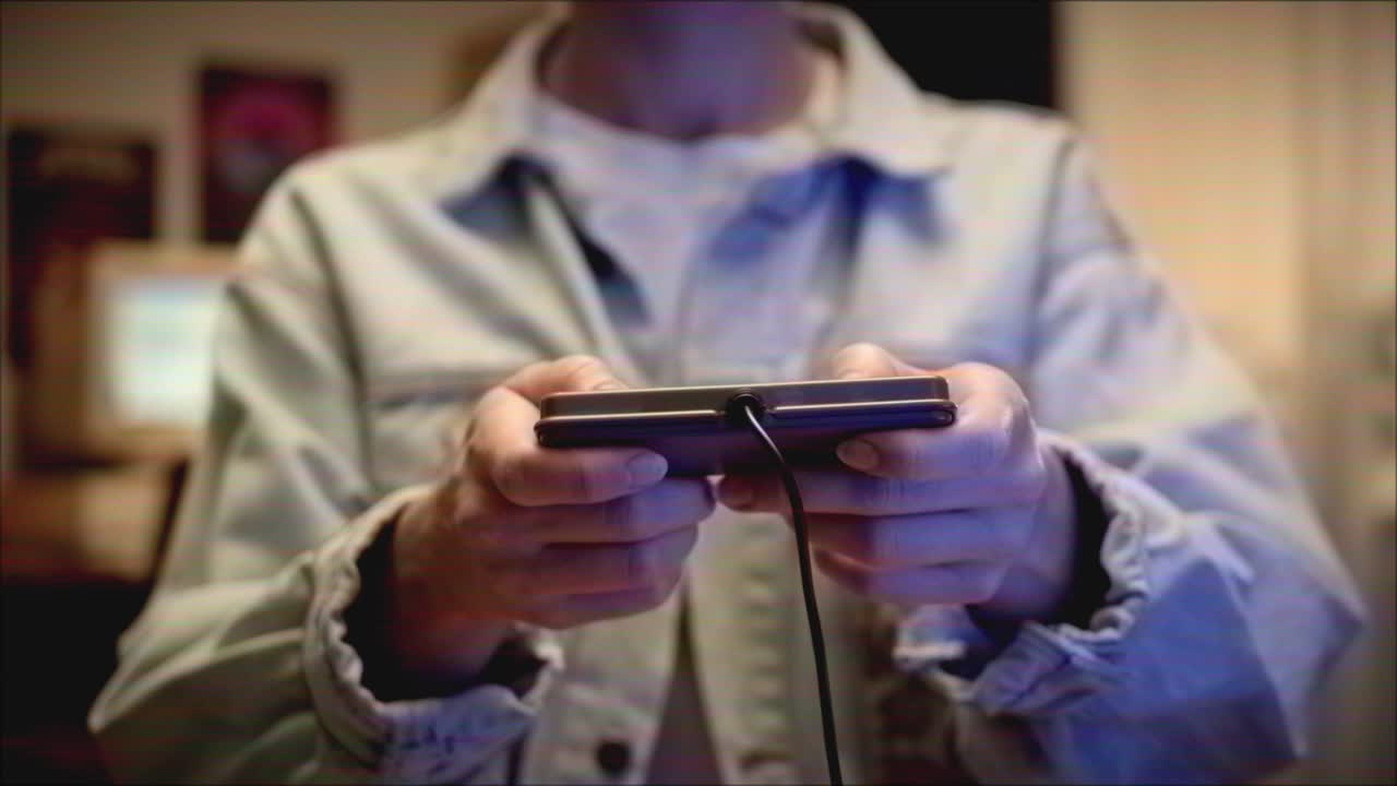 Person Playing a Retro Video Game Console