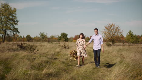 Loving-Couple-Walking-On-A-Meadow-In-Summer-While-Holding-Hands